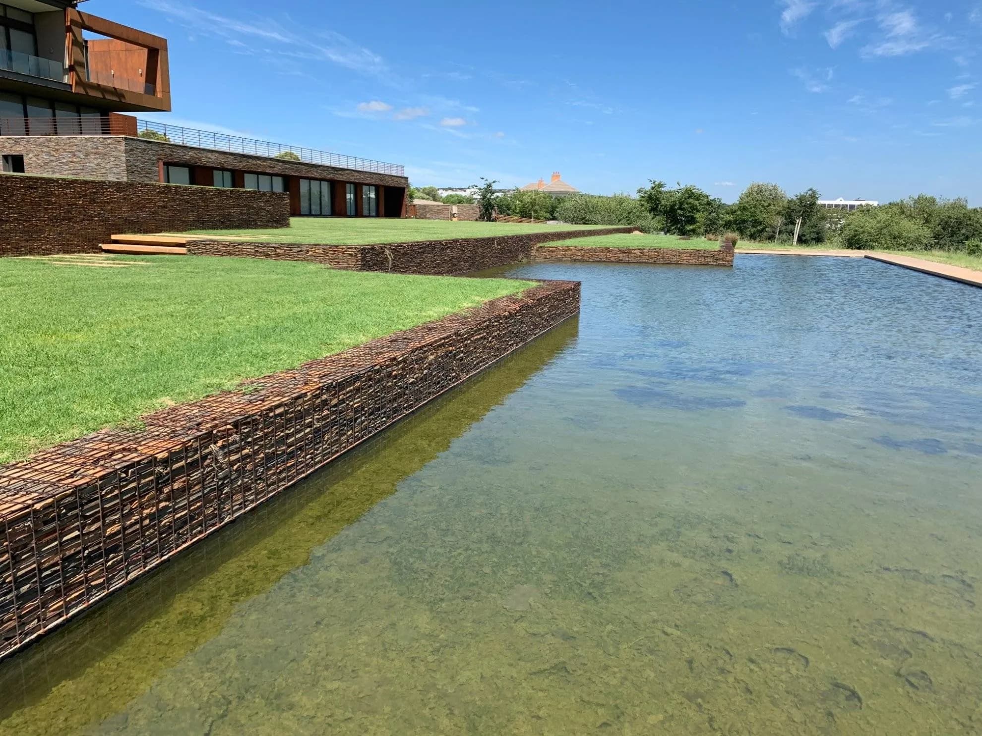 Gabion-edged pond and manicured lawns built by Turfex in Mooikloof