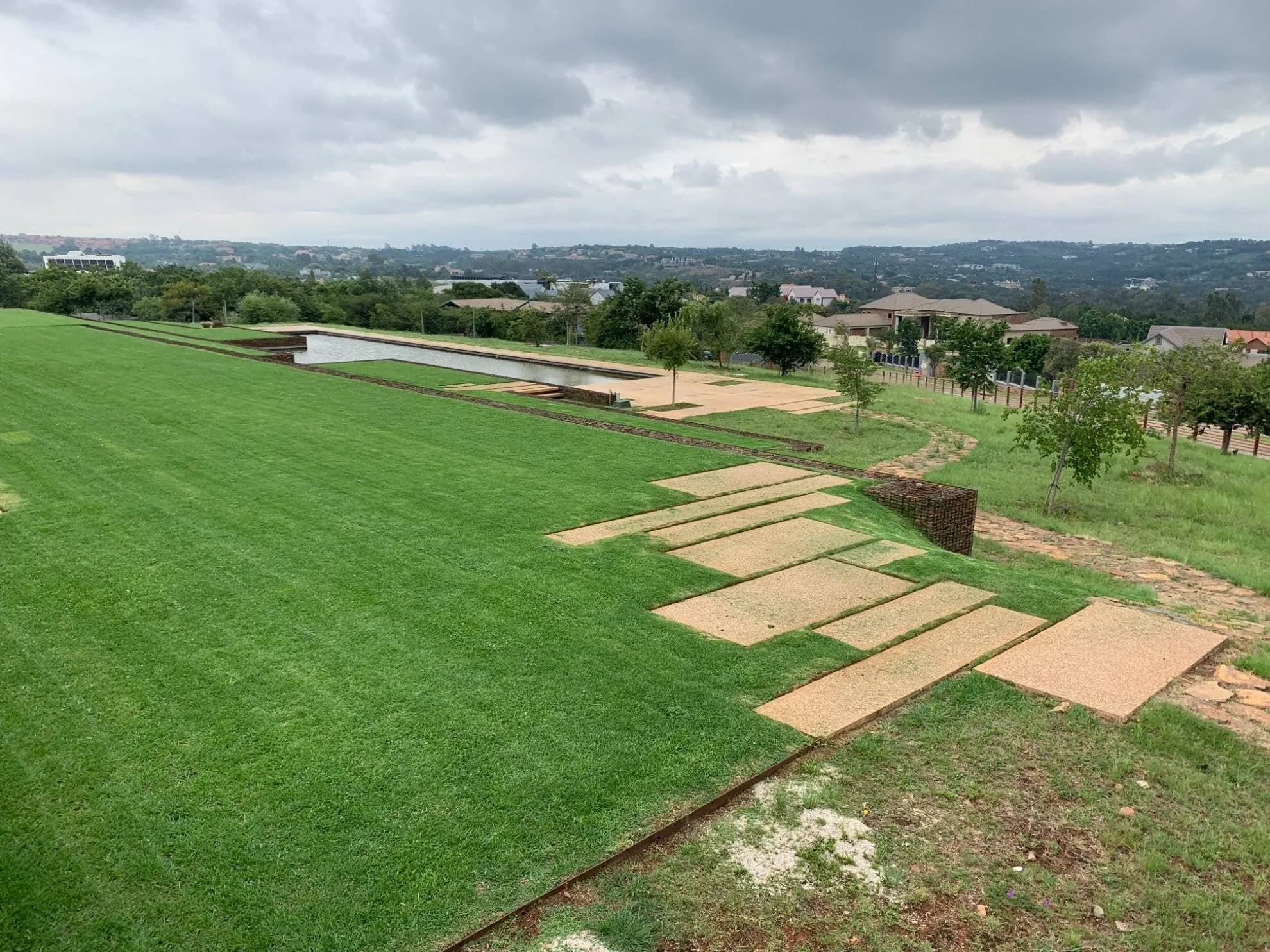 Terraced estate lawns with sandstone steppers, built and maintained by Turfex in Mooikloof