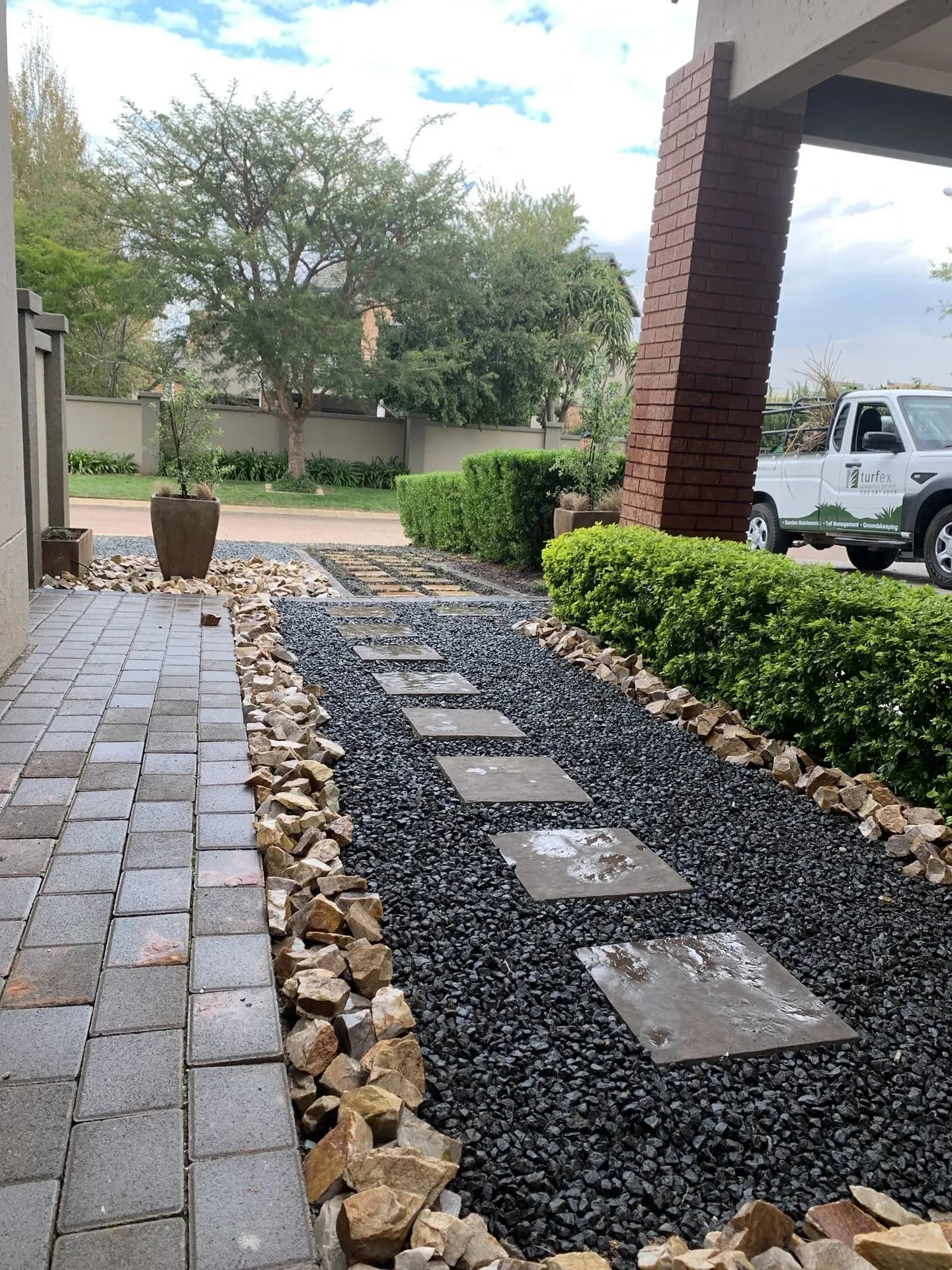Stepping-stone path with pebble beds and clipped hedges built by Turfex